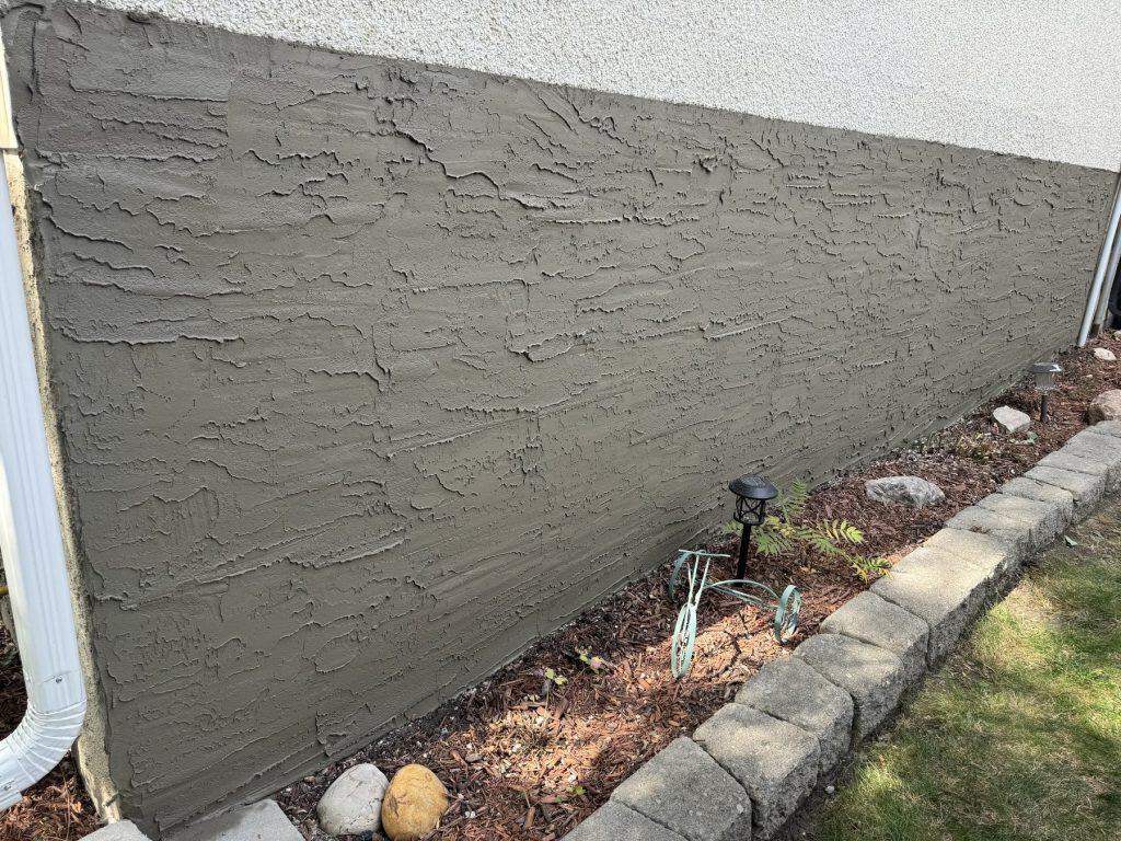 Finished foundation parging on a Sherwood Park home by J and J Coatings