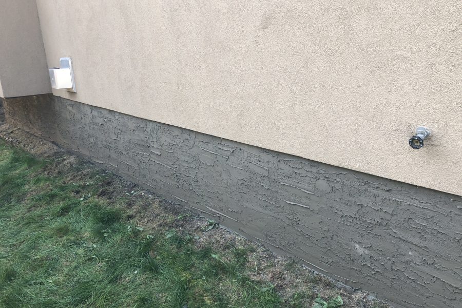 Acrylic stucco above cementitious parging on an Edmonton foundation