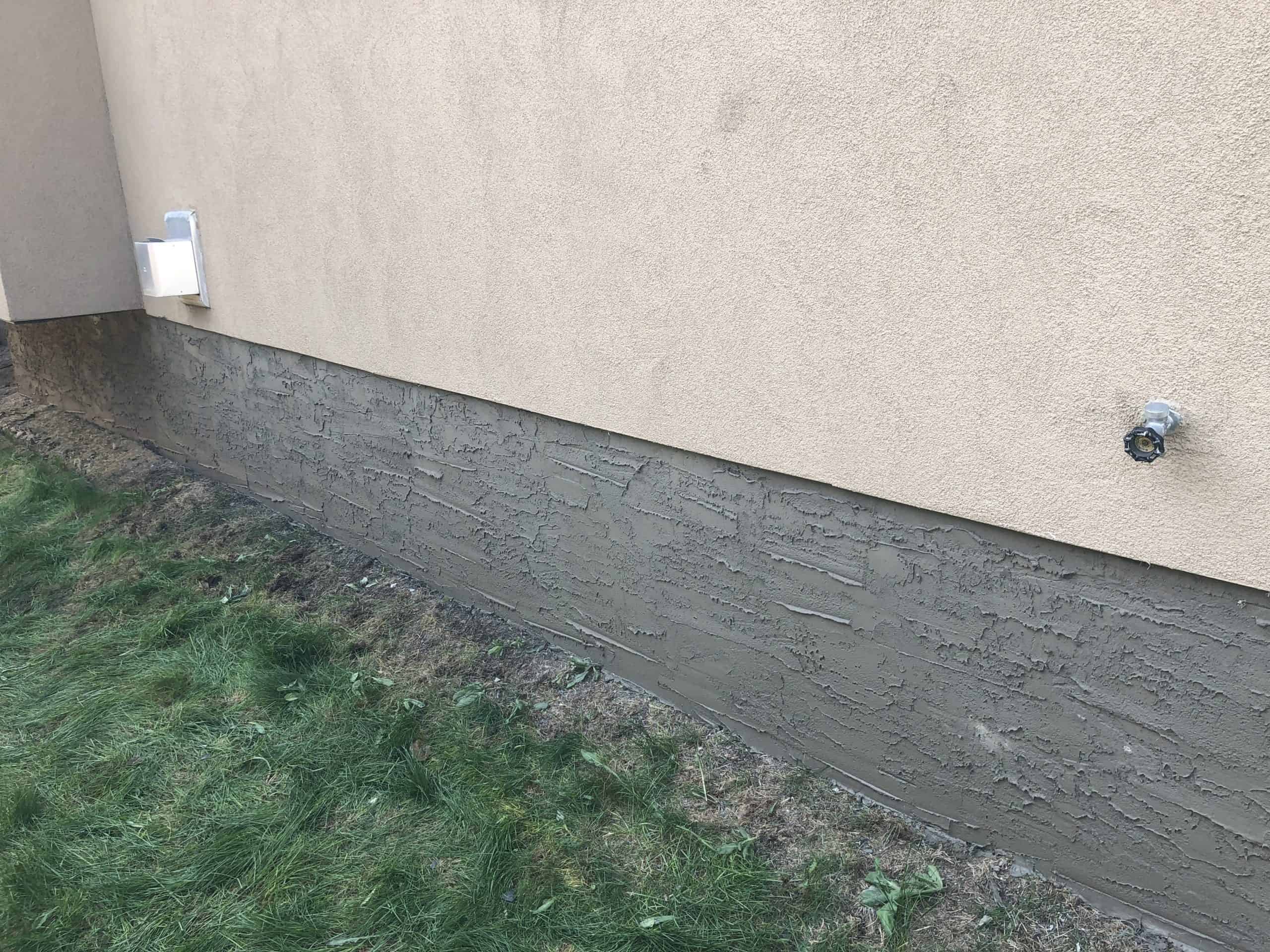 Acrylic stucco above cementitious parging on an Edmonton foundation